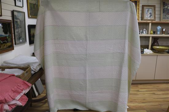 An off-white quilt with blue stitching, a reversible blue and cream quilt, a creamy oyster quilt and a mint green quilt (4)